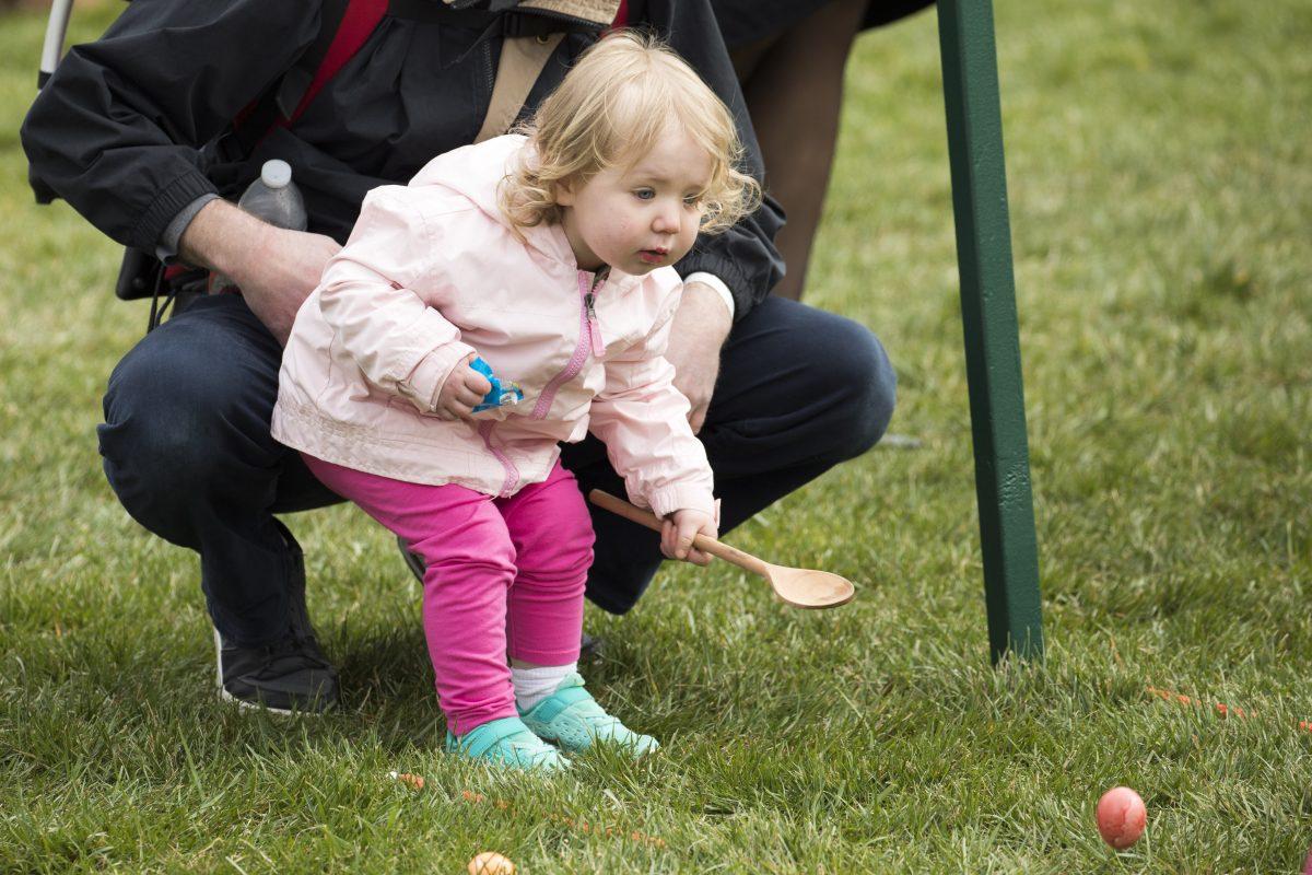 A little girl rolls an egg at the annual Easter Egg Roll on the South Lawn of the White House on April 2, 2018. (Samira Bouaou/The Epoch Times)