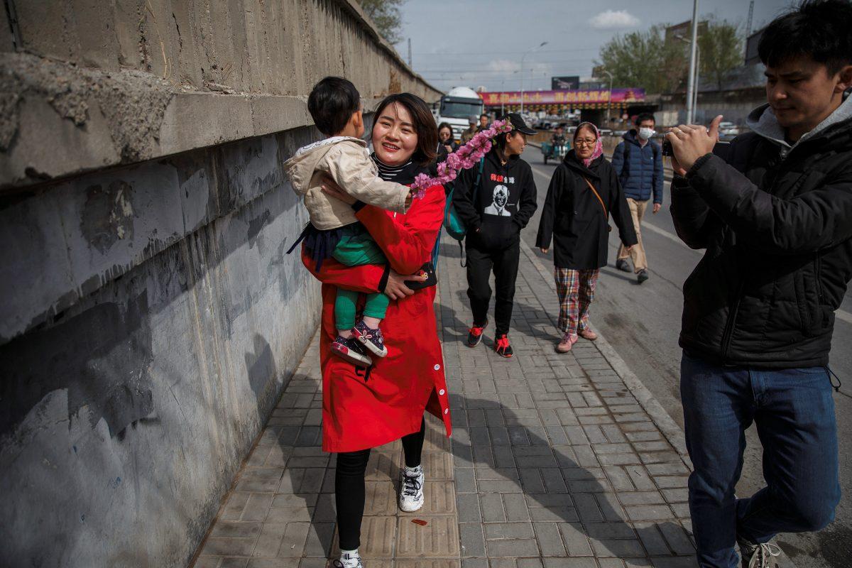 Li Wenzu, the wife of detained Chinese rights lawyer Wang Quanzhang, is followed by reporters and friends as she walks away from a Supreme People's Court complaints office in Beijing on April 4, 2018. (Damir Sagolj/Reuters)
