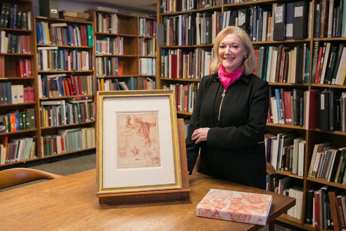 Dr. Carmen Bambach, curator of Italian and Spanish drawings at The Metropolitan Museum of Art, with "Studies for the Libyan Sibyl (recto)," circa 1510–1511, by Michelangelo Buonarroti (1475–1564) and the exhibition catalog she wrote for the "Michelangelo: Divine Draftsman and Designer” exhibition, in the study room for drawings and prints at The Metropolitan Museum of Art, on March 13, 2018. (Benjamin Chasteen/The Epoch Times)