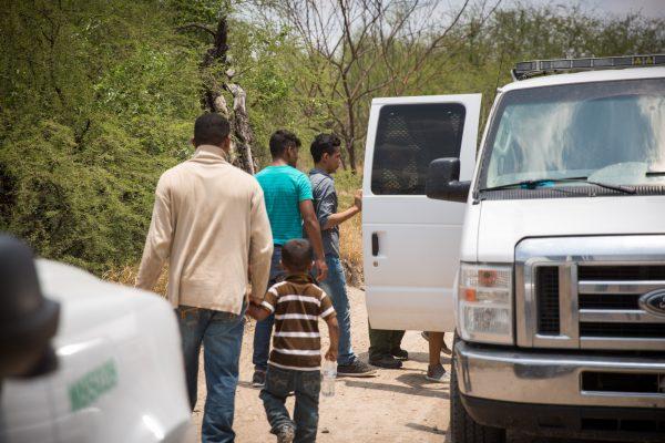 Border Patrol agents lead illegal immigrants to a van for transport to detention facilities in Hidalgo County, Texas, on May 26, 2017. (Benjamin Chasteen/The Epoch Times)