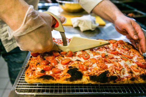 No wheels in sight: A pair of sturdy scissors cuts through the thick and crispy crust. (Channaly Philipp/The Epoch Times)