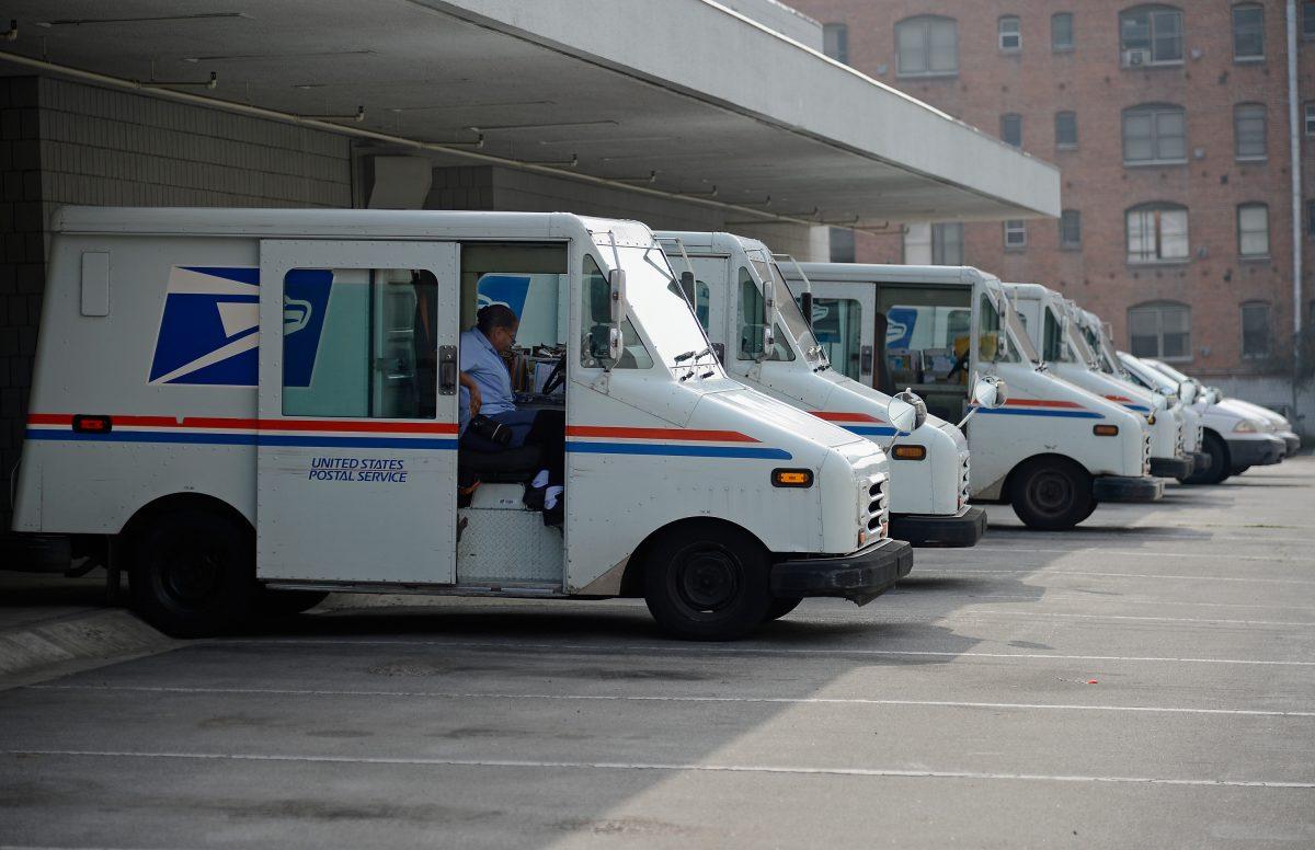 A U.S. Postal service employee loads his van as he prepares to leave the loading dock to deliver mail from the Los Feliz Post Office in Los Angeles on Feb. 6, 2013. (Kevork Djansezian/Getty Images)