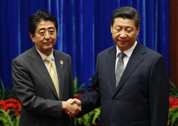 Japan's Prime Minister Shinzo Abe (L) shakes hands with Chinese leader Xi Jinping during their meeting at the Great Hall of the People, in Beijing, China, on November 10, 2014. (Kim Kyung-Hoon-Pool/Getty Images)