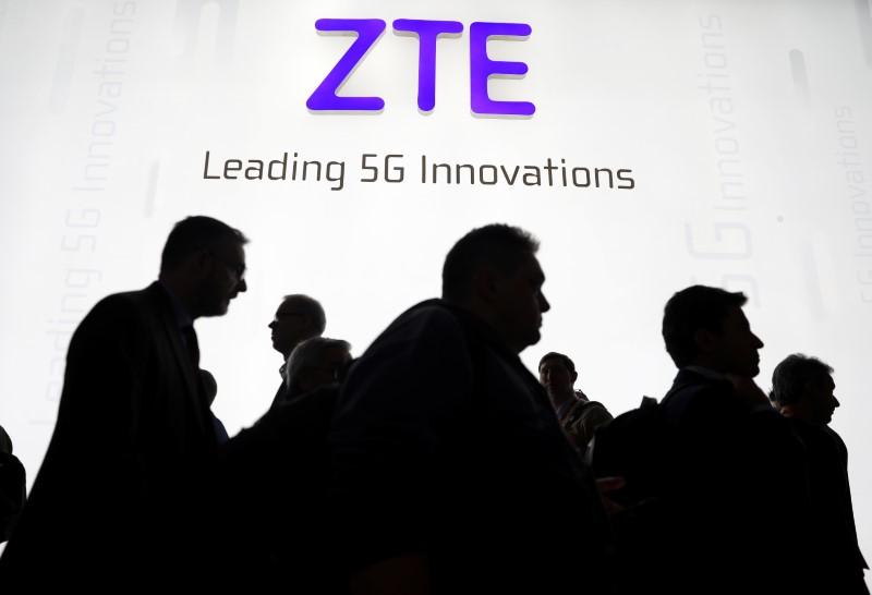 Visitors pass in front of the ZTE booth at the Mobile World Congress in Barcelona, Spain, on February 26, 2018. (Sergio Perez/Reuters)
