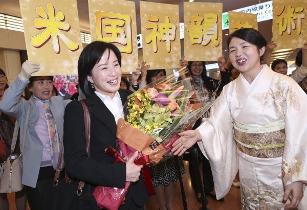 Chen Ying, a flutist for Shen Yun, accepts a bouquet from welcoming fans at the Haneda Airport in Tokyo, Japan, on April 15, 2018. (Yu Gang/The Epoch Times)
