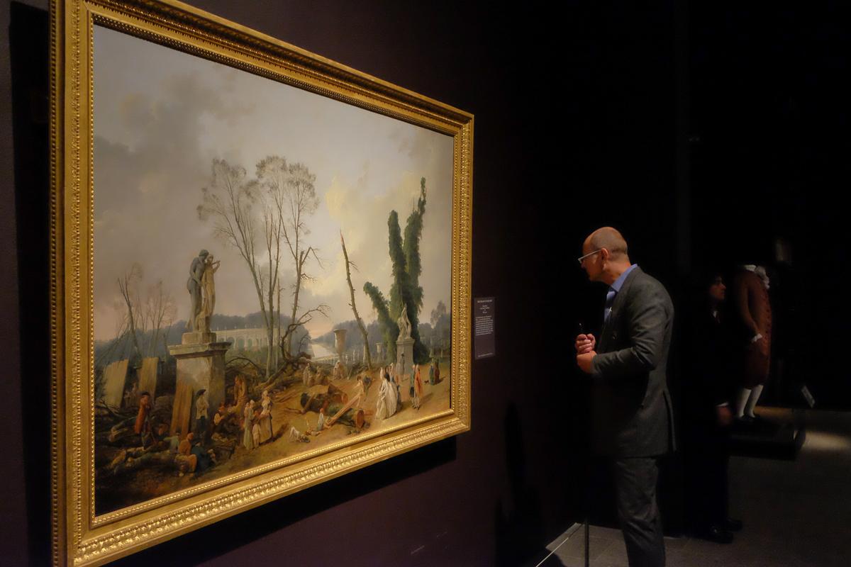 Prince Dimitri of Yugoslavia looks at "The Grove of the Baths of Apollo," 1777, by Hubert Robert (1733–1808), in the "Visitors to Versailles (1682–1789)" exhibition at The Metropolitan Museum of Art in New York on April 9, 2018. (Hiroshi Nogami/The Epoch Times)