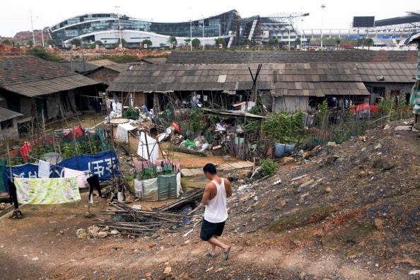 Li Guang, an unemployed farmer who was evicted from his home to make way for the Loudi City Construction and Investment Co.-financed sports stadium, walks into a temporary village near the stadium, in Hunan Province, China, on June 17, 2011. (Adam Dean/Bloomberg via Getty Images)