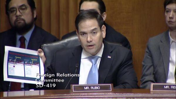 Senator Marco Rubio (R-Fla.) holding a printout of screenshots of U.S. State Department websites that shows the flag of Taiwan was removed, during a hearing over the nomination of Susan Thornton on Feb. 14 at the Dirksen Senate Office Building. (Screenshot via Senate hearing video).