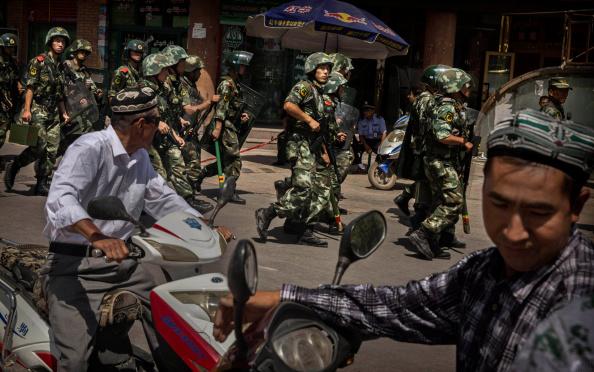 Chinese soldiers in riot gear secure the area outside the Id Kah Mosque, after Imam Jumwe Tahir was killed by assailants following early morning prayers on July 30, 2014 in old Kashgar, Xinjiang Uyghur Autonomous Region, China. (Kevin Frayer/Getty Images)
