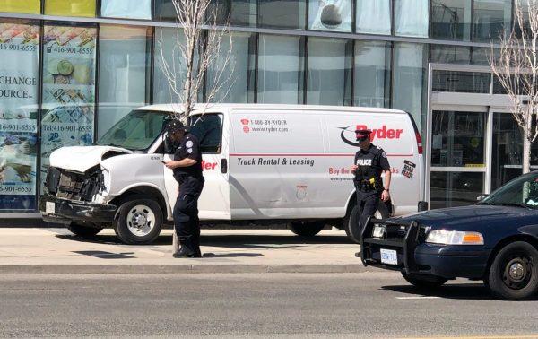 Police investigate the crime scene where a white rental van, shown in the photo, struck dozens of pedestrians near the busy intersection of Yonge St. and Finch Ave. in Toronto. (Teng Dongyu/The Epoch Times)