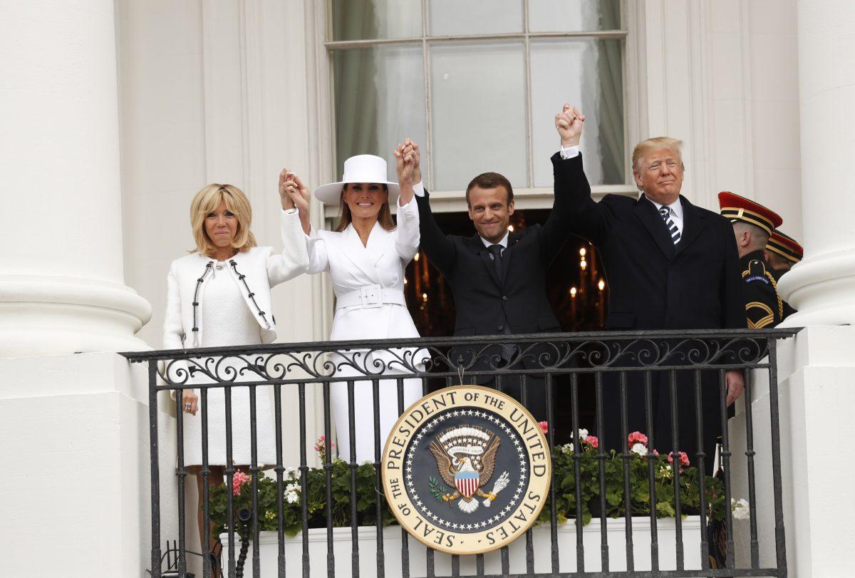 President Donald Trump (R), first lady Melania Trump, French President Emmanuel Macron and his wife Brigitte Macron (L) raise their hands in the air while on the Truman Balcony during the official arrival ceremony for the Macrons on the South Lawn of the White House in Washington on April 24, 2018. (REUTERS/Kevin Lamarque)