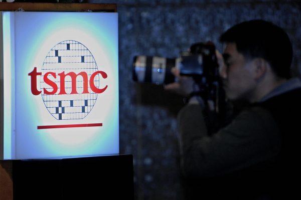 A photographer takes a shot beside a Taiwan Semiconductor Manufacturing Company (TSMC) logo, during a quarterly report meeting in Taipei on April 26, 2007. (Sam Yeh/AFP/Getty Images)```