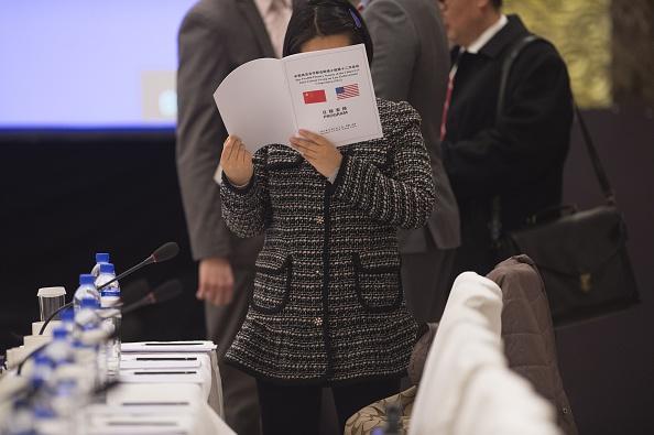 A woman reads a program prior the speech of Deputy Chief of Mission at the US Embassy, Dan Kritenbrink and Chinese Vice Foreign Minister Liu Zhenmin in Beijing on December 3, 2014. (FRED DUFOUR/AFP/Getty Images)