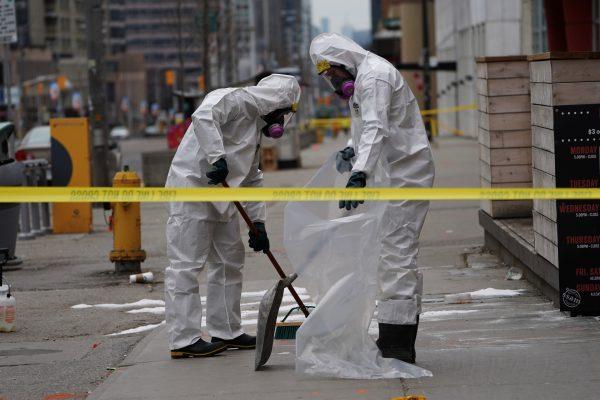 A work crew in protective clothing cleans a sidewalk a day after a van struck multiple people along a major intersection in north Toronto, Ontario, Canada, April 24, 2018. (Reuters/Carlo Allegri)