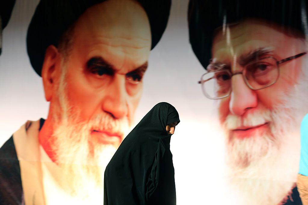 An Iranian woman walks past a giant poster showing Ayatollah Ali Khamenei (R) and the founder of Iran's Islamic republic, Ayatollah Ruhollah Khomeini, on Feb. 1, 2015, in a suburb of Tehran. (Atta Kenare/AFP/Getty Images)