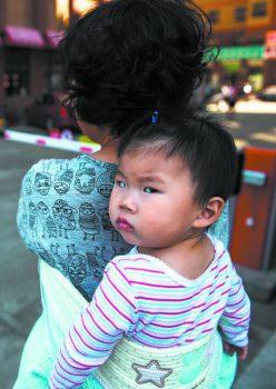 A woman carries a baby in Yanji, in China’s northeast Jilin Province, on June 24, 2015. (GREG BAKER/AFP/GETTY IMAGES)