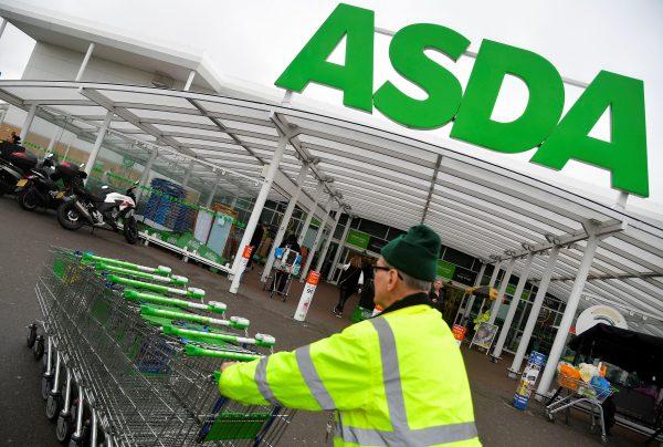 A worker pushes shopping trolleys at an Asda store in west London, Britain, April 28, 2018. (Reuters/Toby Melville)
