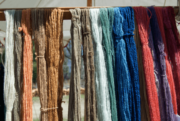 Different hues of wool drying in the sun, such as blue from indigo and yellow from onion skins. (Channaly Philipp/The Epoch Times)