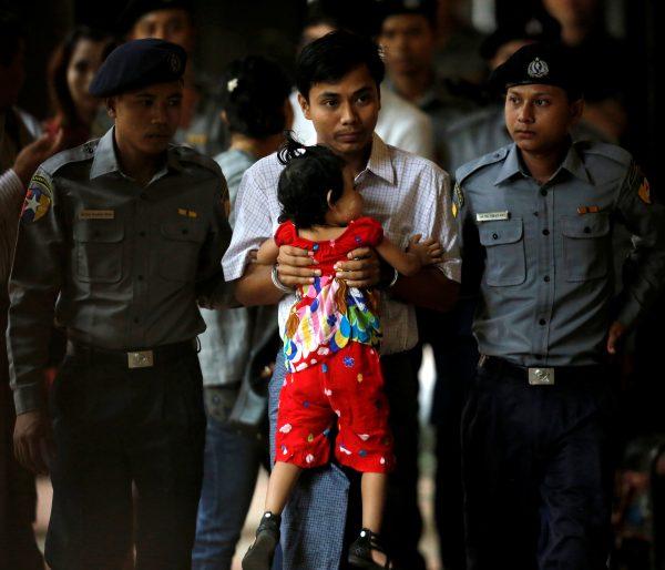 Detained and handcuffed Reuters journalist Kyaw Soe Oo carries his daughter Moe Thin Wai Zin while arriving for a court hearing in Yangon, Myanmar, May 2, 2018. (Reuters/Ann Wang)