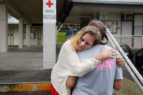 Carolyn McNamara, 70, hugs her neighbor Paul Campbell, 68, at an evacuation center in Pahoa after moving out of their homes in the Puna community of Leilani Estates after the Kilauea Volcano, one of five on the island, erupted after a series of earthquakes over the last couple of days on May 4, 2018. (REUTERS/Terray Sylvester)