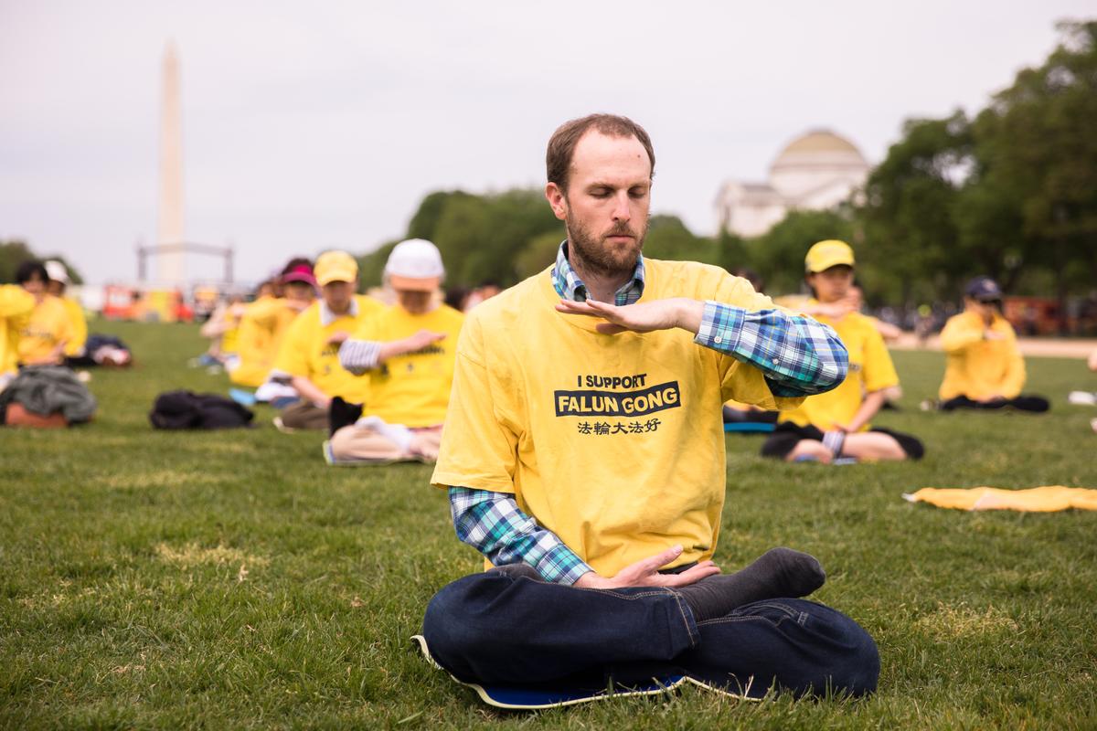 A Falun Dafa practitioner meditates during the World Falun Dafa Day celebration on the National Mall in Washington on May 5, 2018. (Samira Bouaou/The Epoch Times)