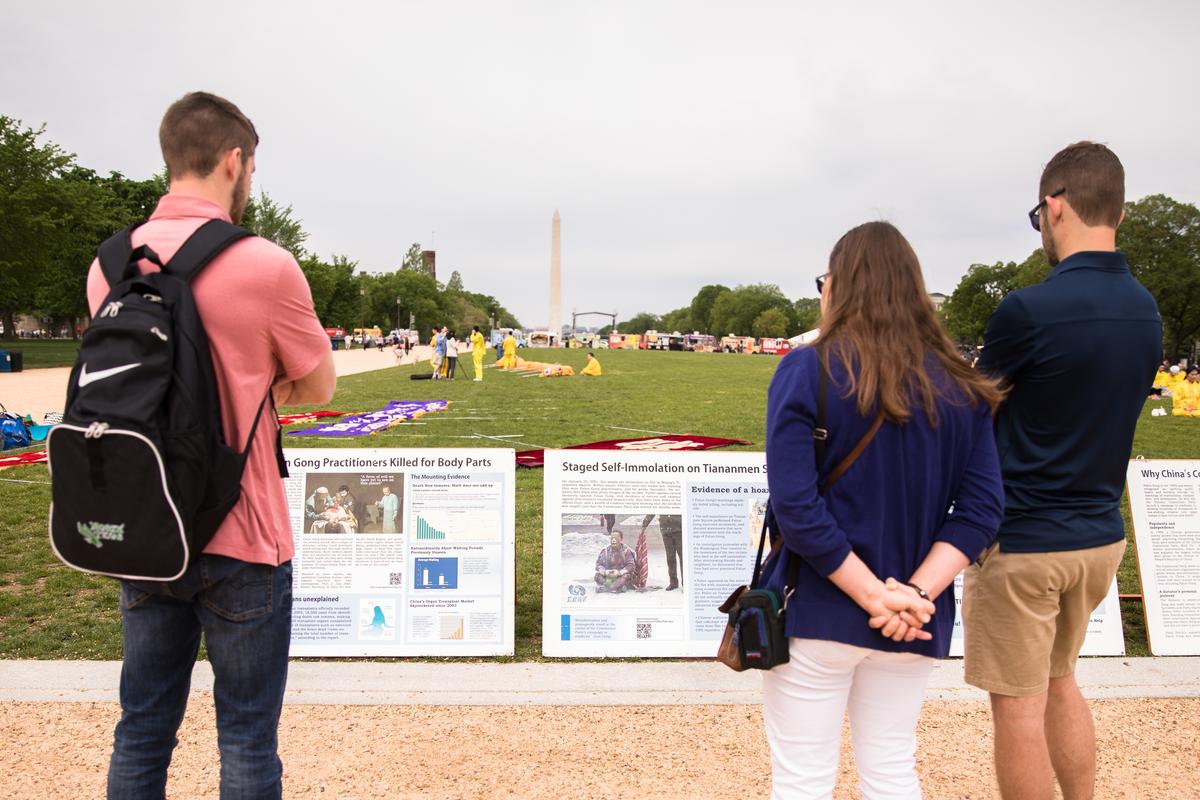 People look at display boards with information on the persecution of Falun Dafa, on the National Mall on May 5, 2018. (Samira Bouaou/The Epoch Times)