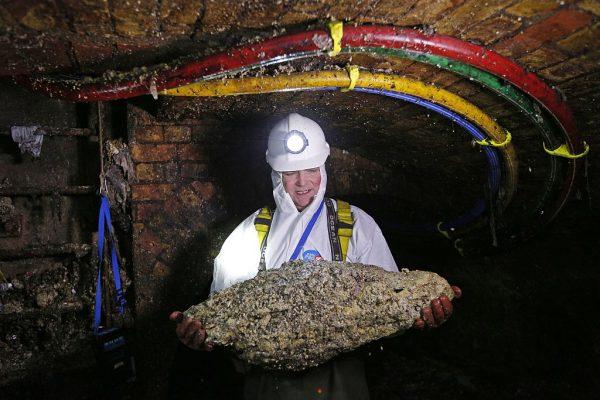 Tim Henderson, a "flusher" or trunk sewer technician, holds a "fatberg" as he works in the intersection of the Regent Street and Victoria sewer in London on Dec. 11, 2014. (Adrian Dennis/AFP/Getty Images)