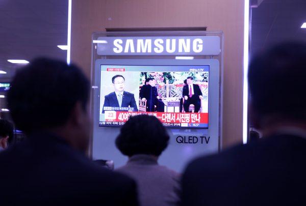 People watch a TV news report about the meeting between North Korean leader Kim Jong Un and Chinese leader Xi Jinping at a railway station in Seoul, South Korea on May 8, 2018. (Kwak Sung-Kyung/Reuters)