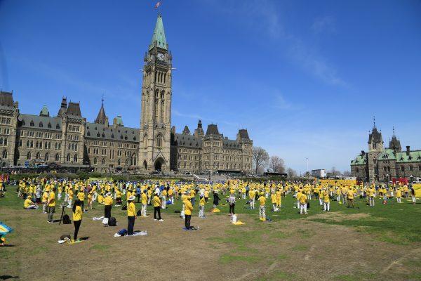 Falun Dafa adherents perform the Falun Dafa exercises as part of celebrations for the Falun Dafa Day on Parliament Hill in Ottawa on May 9, 2018. (Jonathon Ren/The Epoch Times)