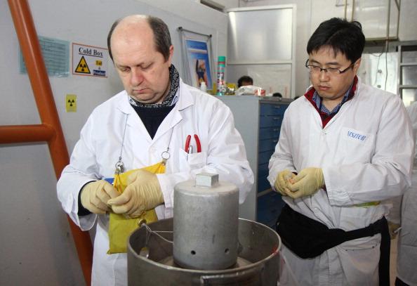 Unidentified International Atomic Energy Agency (IAEA) inspectors seal after disconnecting the connections between the twin cascades for 20 percent uranium production at nuclear power plant of Natanz. (Photo credit should read KAZEM GHANE/AFP/Getty Images)