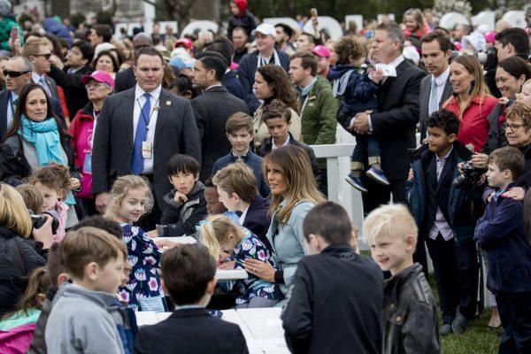 First Lady Melania Trump sits with children as they write messages to military troops at the annual Easter Egg Roll on the South Lawn of the White House on April 2, 2018. (Samira Bouaou/The Epoch Times)