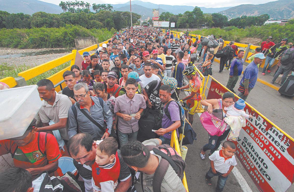  Venezuelan citizens cross the Simón Bolívar International Bridge from San Antonio del Táchira in Venezuela to Norte de Santander Province of Colombia on Feb. 10. Oil-rich and once one of the wealthiest countries in Latin America, Venezuela now faces economic collapse and widespread popular unrest. (GEORGE CASTELLANOS/AFP/GETTY IMAGES)