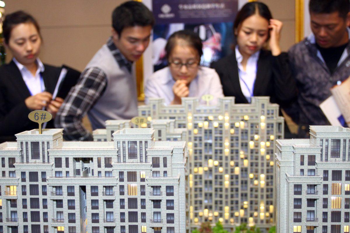 Customers and real estate agents looking at several building models at a real estate exhibition in Jiashan County, in eastern China's Zhejiang Province on Oct. 19, 2012. (AFP/Getty Images)