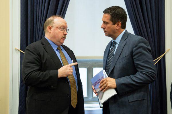 Richard D Fisher Jr., International Assessment and Strategy Center, gives a book titled China's Military Modernization to Rep. Devin Nunes after a Permanent Select Committee on Intelligence hearing on China’s Worldwide Military Expansion at the Rayburn House Office Building at U.S. Congress in Washington on May 17, 2018. (Samira Bouaou/The Epoch Times)