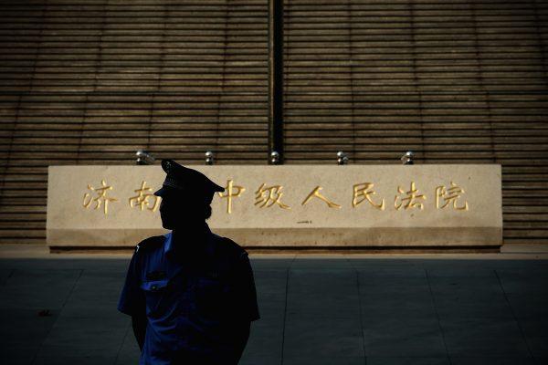A policeman stands guard outside the Jinan Intermediate People's Court in Jinan City, Shandong Province in China on August 21, 2013. (Feng Li/Getty Images)