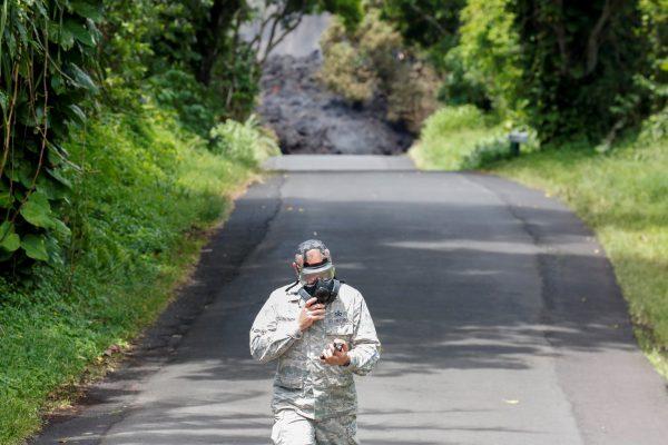 Lieutenant Colonel Charles Anthony, of the Hawaii National Guard, measures sulfur dioxide gas levels at a lava flow on Highway 137 southeast of Pahoa during ongoing eruptions of the Kilauea Volcano in Hawaii, U.S., May 20, 2018. (Reuters/Terray Sylvester)