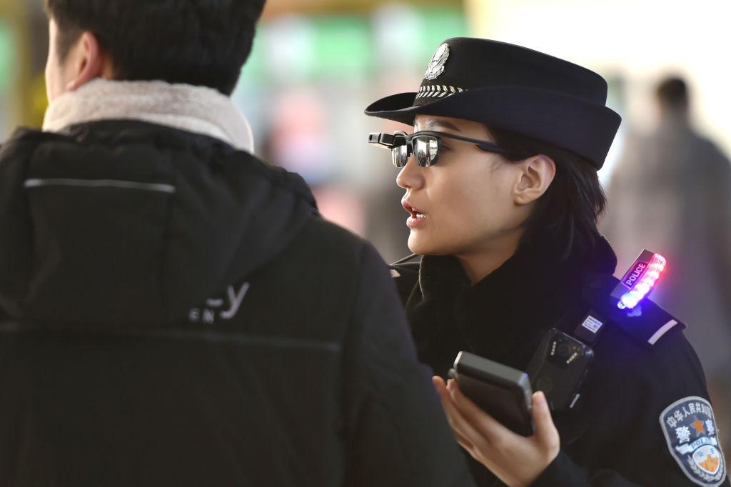 A police officer (R) wears a pair of smart glasses with a facial recognition system at Zhengzhou East Railway Station in Zhengzhou, Henan Province, on Feb. 5, 2018. (AFP/Getty Images)