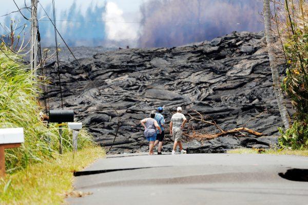Onlookers stare at the lava field in the Leilani Estates near Pahoa, May 24, 2018. (Reuters/Marco Garcia)