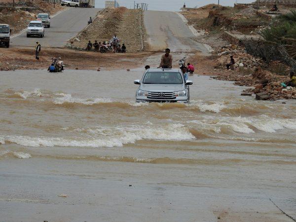 People ride on the back of a truck driving through a flooded road after Cyclone Mekunu hit Socotra Island, Yemen, May 25, 2018. (Reuters/Stringer)