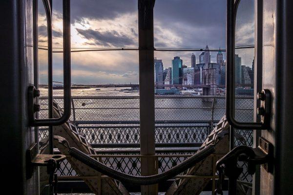 A photograph taken by Richard Koek of the Manhattan skyline as seen from between two subway cars on the Brooklyn Bridge. (Courtesy of Richard Koek)
