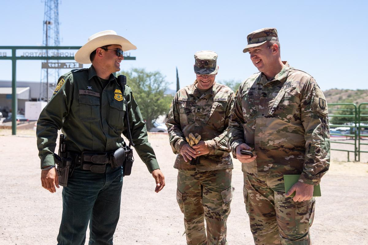 Border Patrol agents and National Guardsmen share a joke near the horse stable area of the Border Patrol station in Nogales, Ariz., on May 23, 2018. (Samira Bouaou/The Epoch Times)