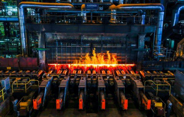A red-hot steel plate passes through a press at the ArcelorMittal steel plant in Ghent, Belgium, May 22, 2018. (Yves Herman/File Photo/Reuters)