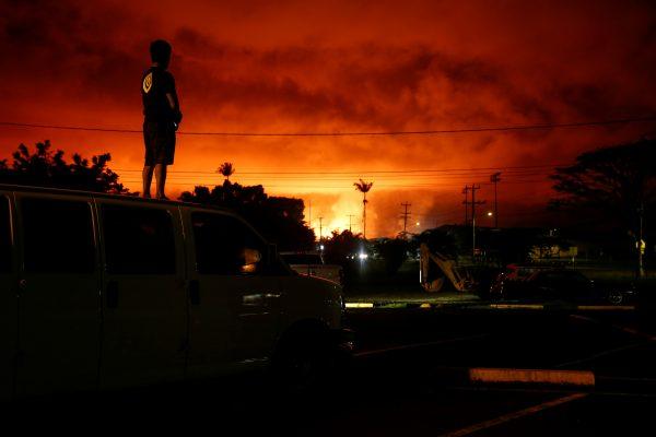 Darryl Sumiki, 52, of Hilo, watches as lava lights up the sky above Pahoa during ongoing eruptions of the Kilauea Volcano in Hawaii, U.S., June 2, 2018. (Reuters/Terray Sylvester)