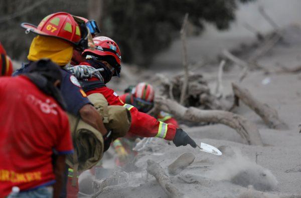 A firefighter shovels ashes while searching for bodies at an area affected by the eruption of the Fuego volcano in the community of San Miguel Los Lotes in Escuintla, Guatemala June 4, 2018. (Reuters/Luis Echeverria)