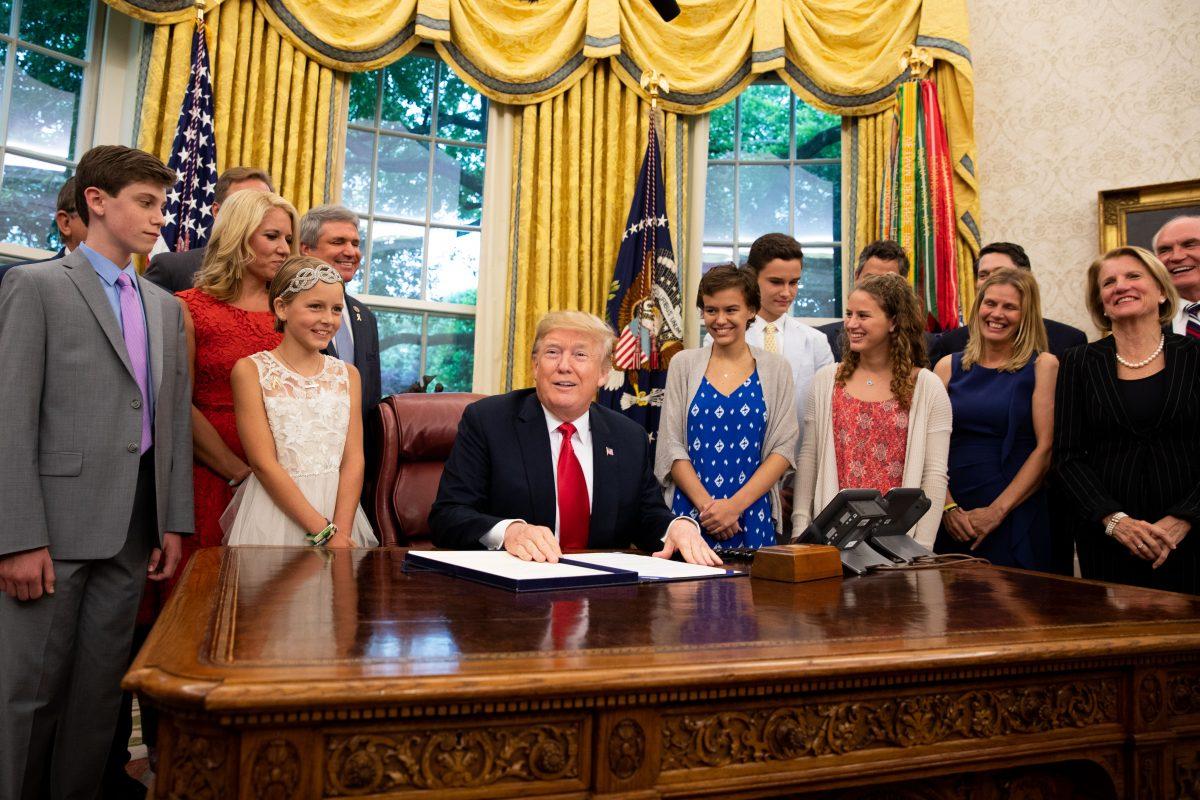President Donald Trump participates in the signing ceremony for S. 292 – The Childhood Cancer Survivorship, Treatment, Access, and Research Act of 2018 in the Oval Office at the White House in Washington on June 5, 2018. (Samira Bouaou/The Epoch Times)