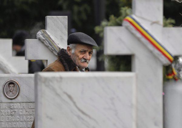 An elderly man walks between the graves in the Heroes' Cemetery in Bucharest, Romania, Thursday, Dec. 21, 2017, during a memorial ceremony for the victims of the 1989 uprising. The anti-communist uprising, which left more than one thousand people dead and ended the rule of dictator Nicolae Ceausescu, started in the western Romanian town of Timisoara on Dec. 16, 1989 and in Bucharest on Dec. 21, 1989. (AP Photo/Vadim Ghirda)