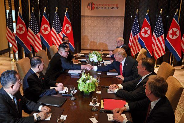 President Donald Trump shakes hands with North Korea's leader Kim Jong Un as they sit down with their respective delegations for the US-North Korea summit, at the Capella Hotel on Sentosa Island in Singapore on June 12, 2018. (SAUL LOEB/AFP/Getty Images)