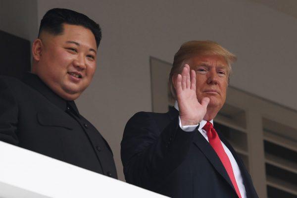 President Donald Trump waves as he and North Korea's leader Kim Jong Un look on from a veranda during their historic US-North Korea summit, at the Capella Hotel on Sentosa Island in Singapore on June 12, 2018. (SAUL LOEB/AFP/Getty Images)