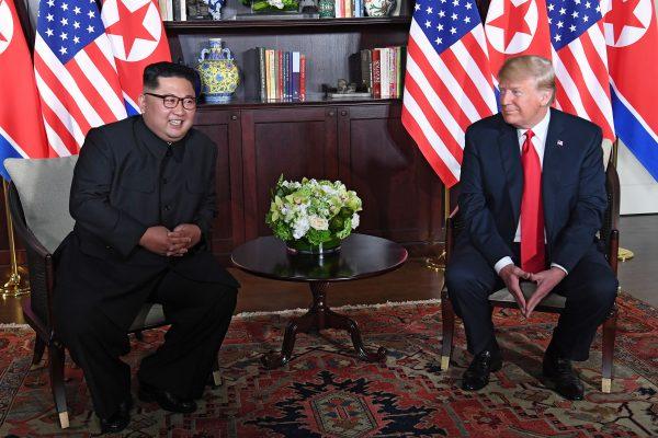 North Korea's leader Kim Jong Un smiles with President Donald Trump as they sit down for their historic US-North Korea summit, at the Capella Hotel on Sentosa Island in Singapore on June 12, 2018. (SAUL LOEB/AFP/Getty Images)