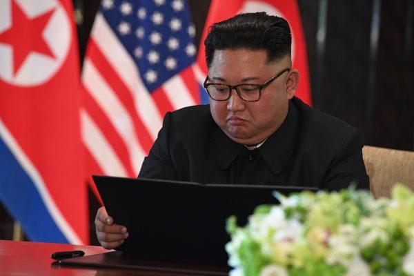 North Korea leader Kim Jong Un looks at his document at a signing ceremony with President Donald Trump (not pictured) during their historic US-North Korea summit in Singapore on June 12, 2018. (SAUL LOEB/AFP/Getty Images)